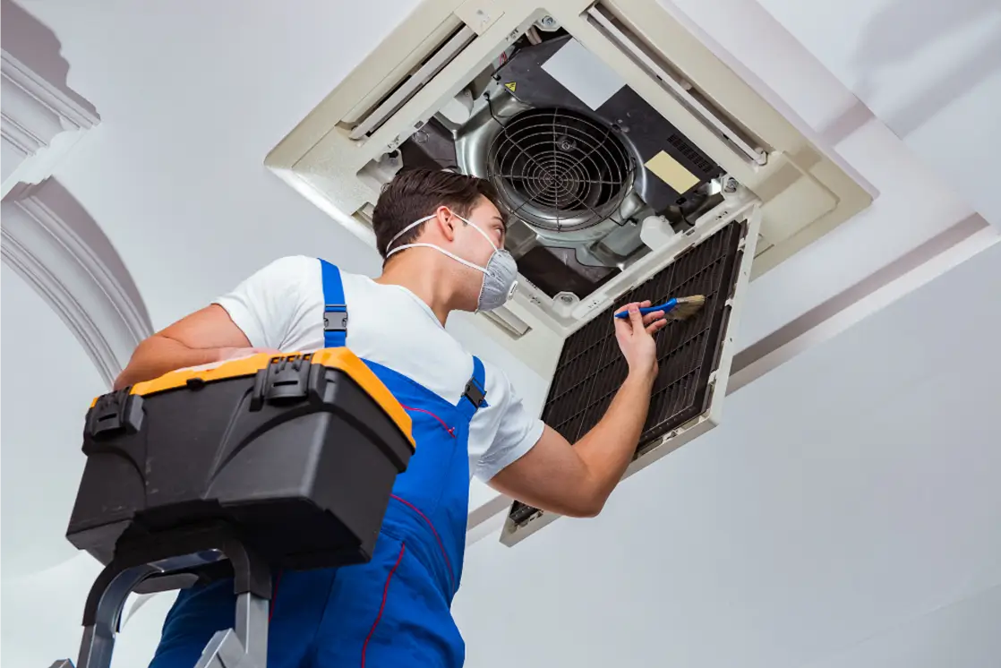 HVAC technician performing seasonal maintenance on a heating and cooling system